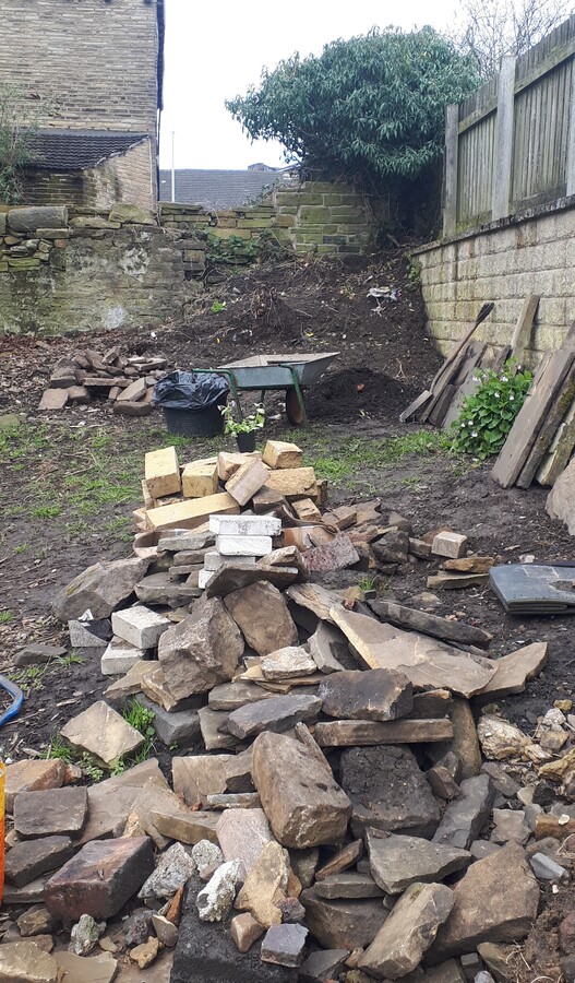 Dug up stone and a huge pile of soil and rubbish in the corner April 2023